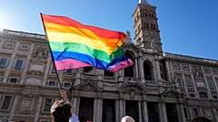 Un manifestante ondea la bandera del arco iris frente a la Basílica de Santa María la Mayor durante la marcha anual del Orgullo, en Roma, el sábado 26 de junio de 2021.