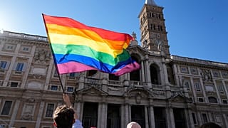 Un manifestante ondea la bandera del arco iris frente a la Basílica de Santa María la Mayor durante la marcha anual del Orgullo, en Roma, el sábado 26 de junio de 2021.