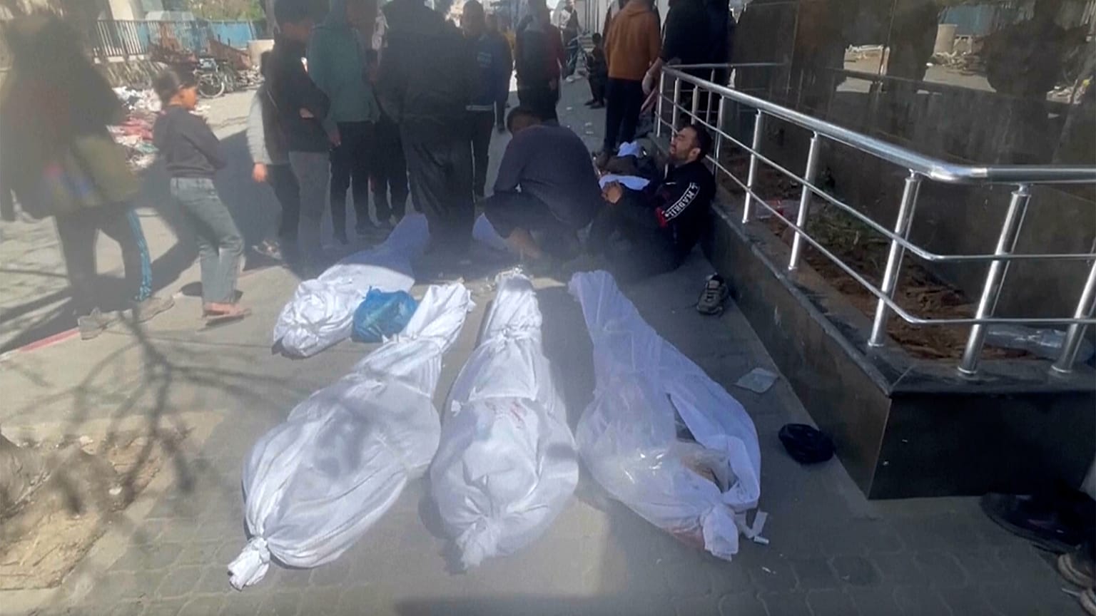 جثث على الأرض ملفوفة بأكفان بيضاء أمام مستشفى الشفاء في مدينة غزة
