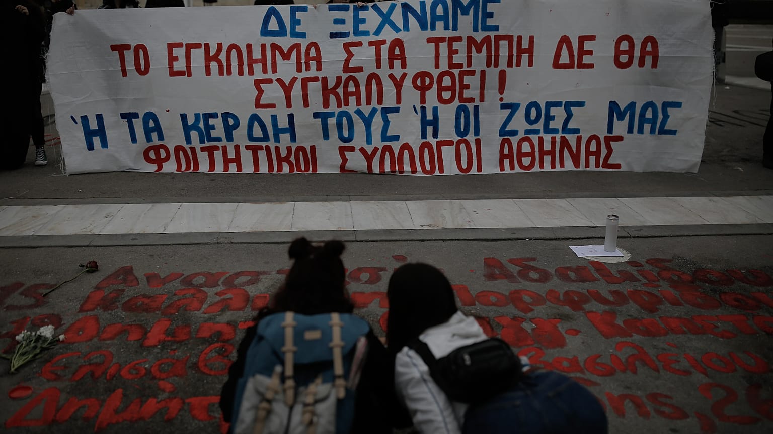 Φοιτητές ξαναγράφουν τα ονόματα των θυμάτων του σιδηροδρομικού δυστυχήματος των Τεμπών μπροστά από το κτίριο της Βουλής