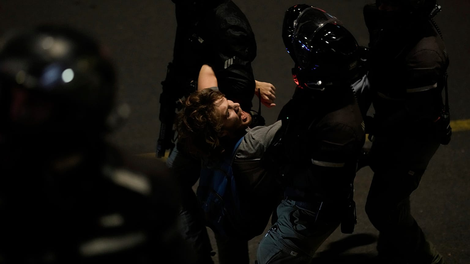 Policía deteniendo manifestante