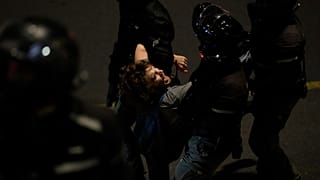 Policía deteniendo manifestante
