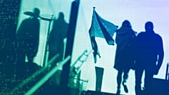 Un couple passe devant les drapeaux de l'UE devant le siège de l'UE à Bruxelles, en octobre 2021