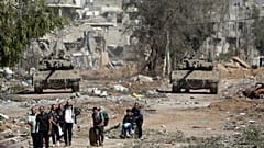 مجموعة من النازحين الفلسطينيين أمام الدبابات الإسرائيلية في قطاع غزة