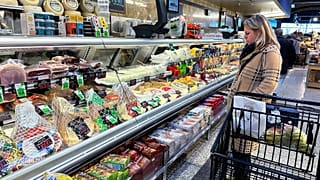 Una mujer comprueba los precios mientras hace la compra en un supermercado de Wheeling, Illinois, el viernes 19 de enero de 2024.