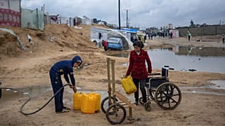Palestinians displaced by the Israeli air and ground offensive on the Gaza Strip gather water in a makeshift tent camp in Rafah on the border with Egypt, 27 January 2024.
