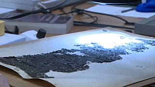 Für das menschliche Auge ist auf dem verkohlten Papyrus nichts mehr zu erkennen.