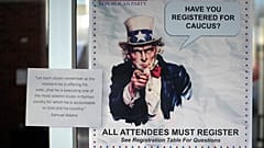 A HAVE YOU REGISTERED FOR CAUCUS sign hangs on a doorway during the Republican caucus at the Millcreek Junior High School on Tuesday, March 5, 2024, in Bountiful, Utah.