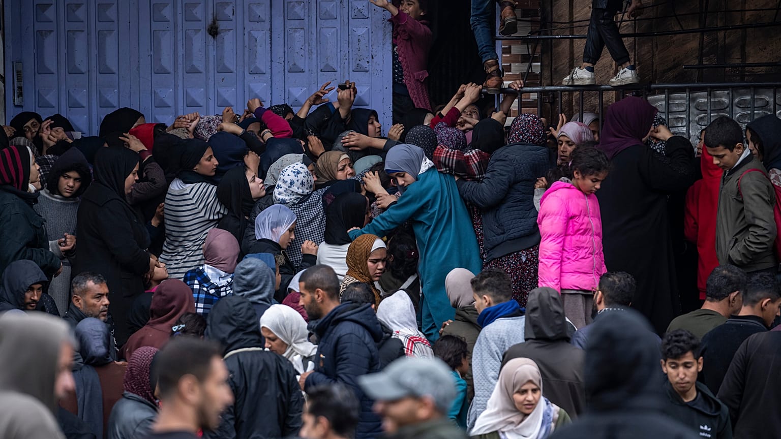 Palestinian crowds struggle to buy bread from a bakery in Rafah, Gaza Strip, Sunday, Feb. 18, 2024.
