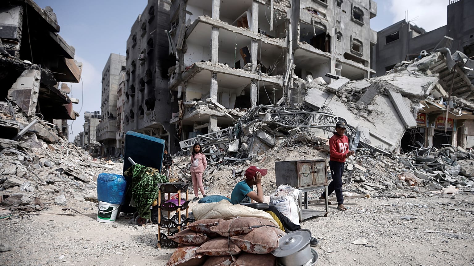 أطفال فلسطينيون يجلسون وسط الدمار الكبير الذي خلفه القصف الإسرائيلي العنيف على خان يونس