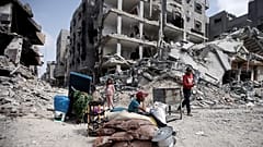 أطفال فلسطينيون يجلسون وسط الدمار الكبير الذي خلفه القصف الإسرائيلي العنيف على خان يونس