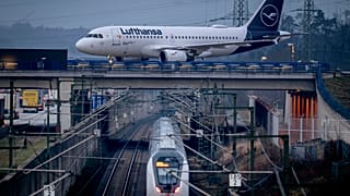 Frankfurt'ta bir demiryolu hattı üzerindeki bir köprüde ilerleyen bir Lufthansa uçağı