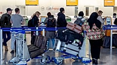 Menschen stehen am Donnerstag, den 7. März 2024, in einem Terminal des Frankfurter Flughafens für Informationen an.