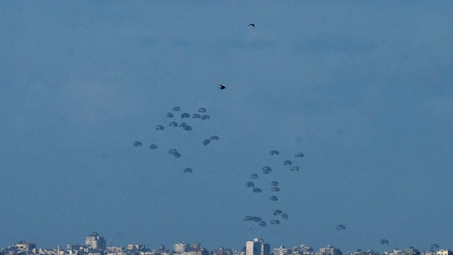 Parachutes drop supplies into the northern Gaza Strip, as seen from southern Israel, Thursday, March 7