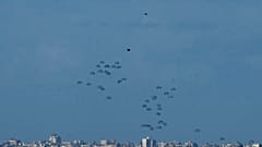 Parachutes drop supplies into the northern Gaza Strip, as seen from southern Israel, Thursday, March 7