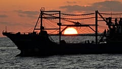 The sun rises while a suspected Chinese militia ship blocks Philippine coast guard ship, not shown, in the disputed South China Sea Tuesday, March 5, 2024.
