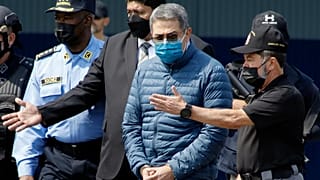 O antigo presidente hondurenho Juan Orlando Hernandez, segundo a contar da direita, é algemado enquanto é extraditado para os Estados Unidos, 21 de abril de 2022