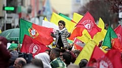 Uma criança segura uma flor e uma bandeira do Partido Socialista é erguida por cima da multidão durante uma ação de campanha eleitoral com o líder do Partido Socialista, 2024