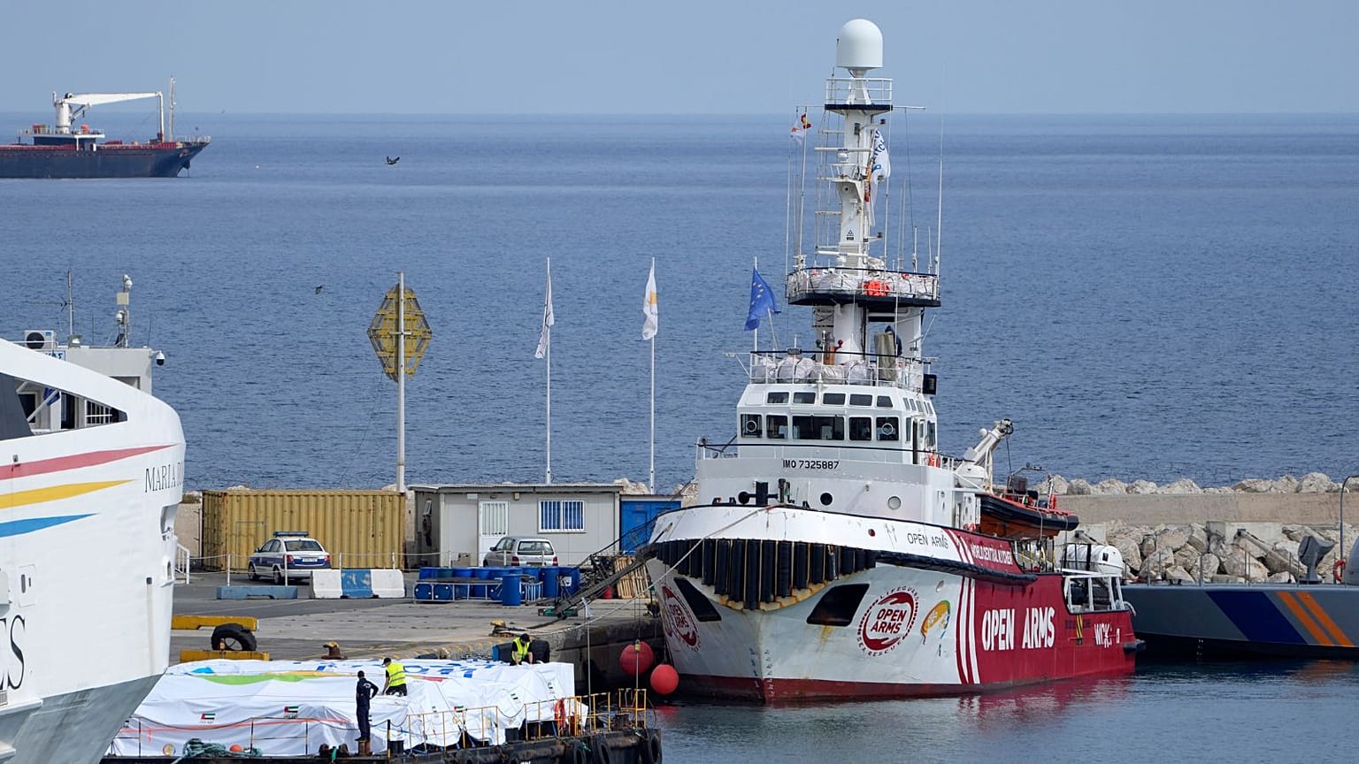Port staffers prepare the aid on a platform near to the docked ship belonging to the Open Arms aid group at the port in Larnaca, Cyprus, on Sunday, March 10, 2024. 