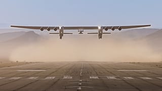 El avión Roc de seis motores despega con el vehículo de pruebas Talon-A-1 acoplado bajo sus alas.