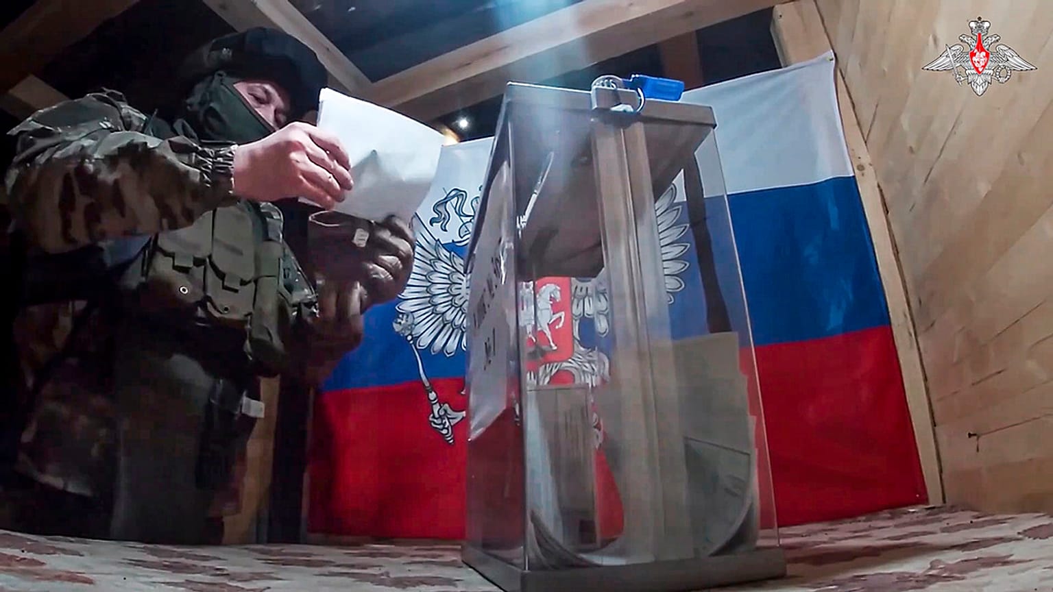 Un militar ruso participa en la votación en un colegio electoral improvisado durante la votación anticipada en las elecciones presidenciales rusas en la región de Donetsk