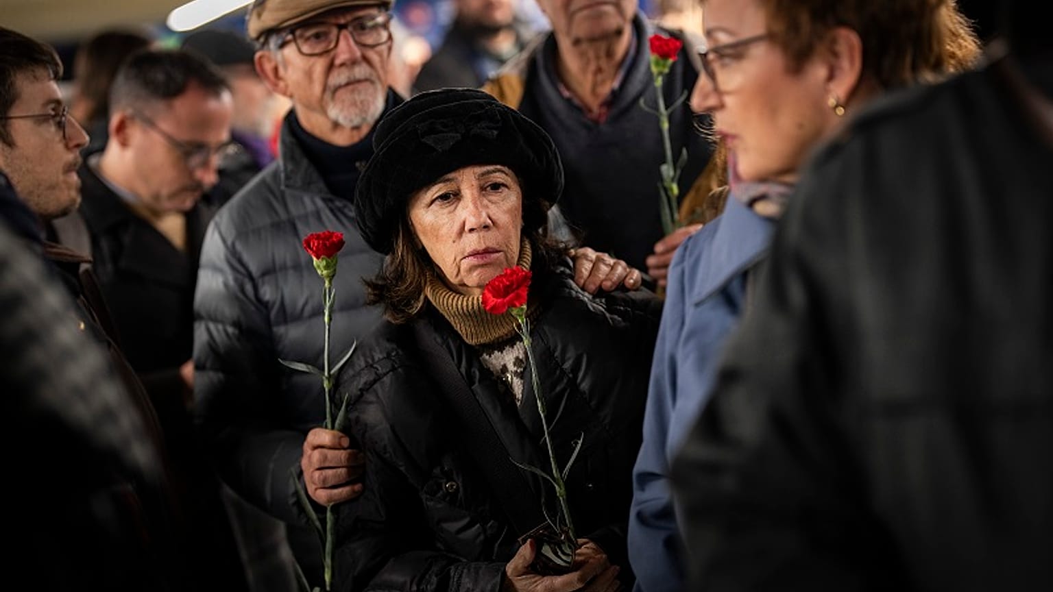 Ciudadanos hacen cola para depositar flores en un monumento a las víctimas del atentado al tren de 2004 dentro de la estación de tren de Atocha en Madrid
