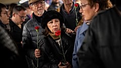 Ciudadanos hacen cola para depositar flores en un monumento a las víctimas del atentado al tren de 2004 dentro de la estación de tren de Atocha en Madrid
