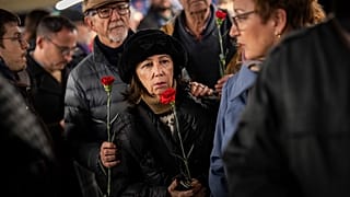 Ciudadanos hacen cola para depositar flores en un monumento a las víctimas del atentado al tren de 2004 dentro de la estación de tren de Atocha en Madrid