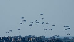 Parachutes drop humanitarian aid into the northern Gaza Strip, as seen from southern Israel, Monday, March 11, 2024. 