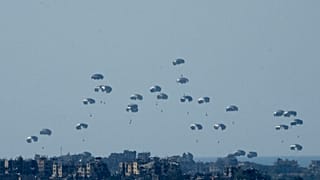 Parachutes drop humanitarian aid into the northern Gaza Strip, as seen from southern Israel, Monday, March 11, 2024.