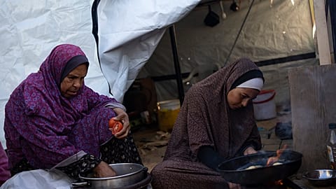 Two Palestinian women prepare food. 