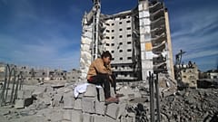 Un garçon palestinien est assis devant un immeuble résidentiel détruit par une frappe israélienne à Rafah, dans la bande de Gaza, le samedi 9 mars 2024. 