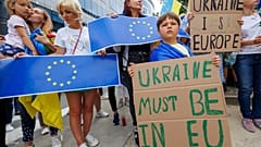 Διαδηλωτές κρατούν πινακίδες και σημαίες της ΕΕ και της Ουκρανίας κατά τη διάρκεια διαδήλωσης υπέρ της Ουκρανίας έξω από τη σύνοδο κορυφής της ΕΕ στις Βρυξέλλες, στις 23 Ιουνίου 2022.