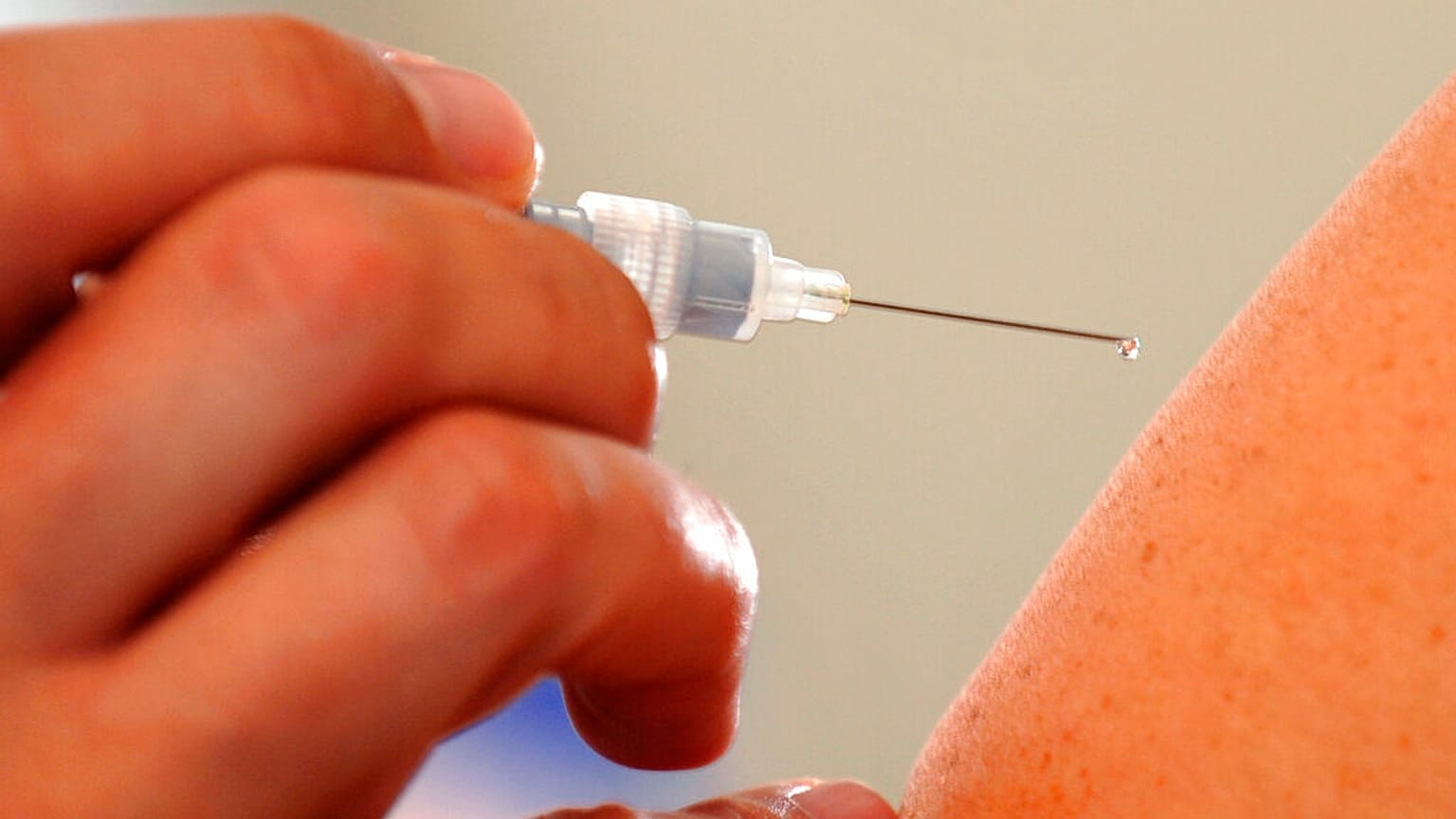 ARQUIVO - Um médico injecta uma vacina contra a gripe num paciente em Dresden, a 10 de outubro de 2008.