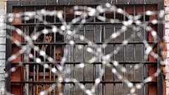 Detenido bielorruso hace gestos desde una celda de un centro de detención en Minsk, Bielorrusia, el 7 de julio de 2011.