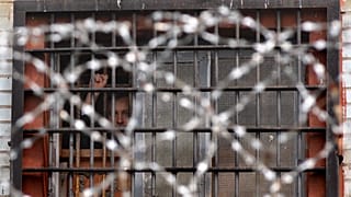Detenido bielorruso hace gestos desde una celda de un centro de detención en Minsk, Bielorrusia, el 7 de julio de 2011.