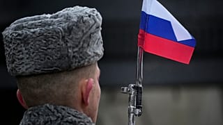 A honour guard soldier holds a rifle with a Russian flag mounted on a gun's bayonet at the monument of the Heroic Defenders of Leningrad in St.Petersburg on 27 January 2024.