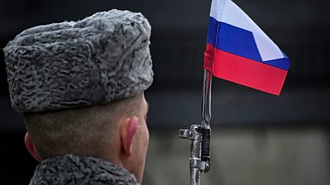 A honour guard soldier holds a rifle with a Russian flag mounted on a gun's bayonet at the monument of the Heroic Defenders of Leningrad in St.Petersburg on 27 January 2024.