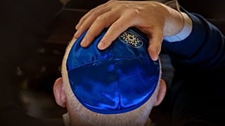 رجل يضع يده على رأسه خلال إحياء ذكرى ضحايا المحرقة في كنيس معبد المرجان في بوخارست