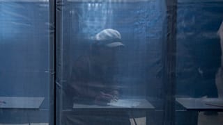 A woman fills in a ballot at a polling station during a presidential election in Russian-controlled Donetsk region of eastern Ukraine, Friday, March 15, 2024.