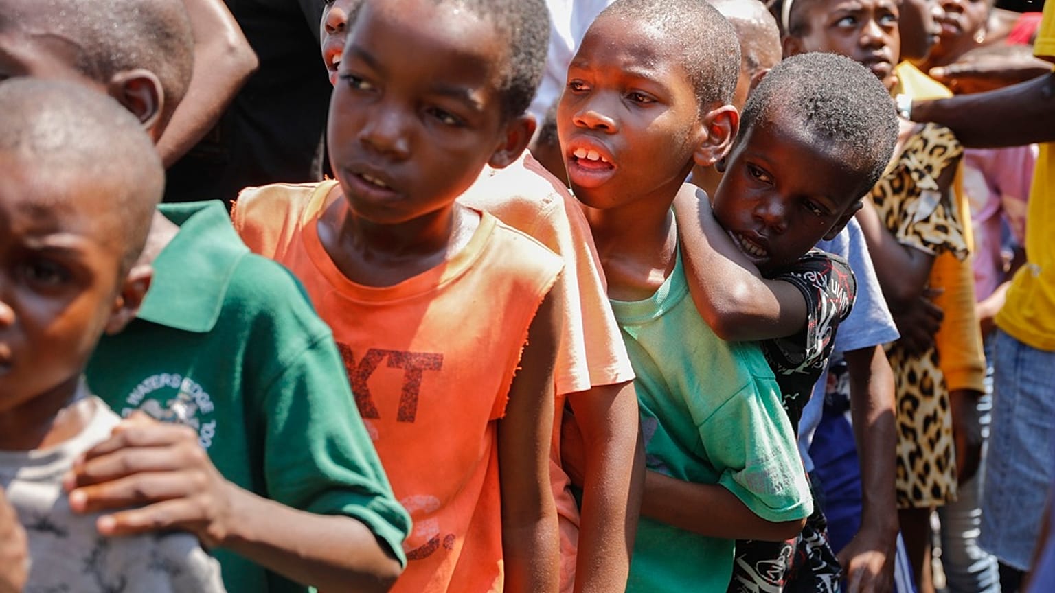 Kinder stellen sich in einer Unterkunft für von Bandengewalt vertriebene Familien in Port-au-Prince, Haiti, am Donnerstag, dem 14. März 2024, an, um Essen zu erhalten.