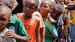 Kinder stellen sich in einer Unterkunft für von Bandengewalt vertriebene Familien in Port-au-Prince, Haiti, am Donnerstag, dem 14. März 2024, an, um Essen zu erhalten.