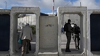 فلسطينيون يعبرون من حاجز قلنديا العسكري الإسرائيلي بالقرب من مدينة رام الله بالضفة الغربية المحتلة إلى القدس. 2024/03/15