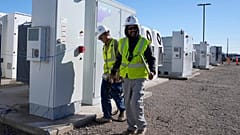 Workers walks the campus of battery storage pods at Orsted's Eleven Mile Solar Center lithium-ion battery storage energy facility Thursday, Feb. 29, 2024, in Coolidge, Ariz. 