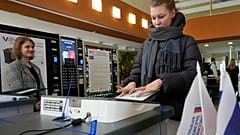 Eine russische Wählerin scannt ihren Stimmzettel ein. Sankt Petersburg, 16. März 2024