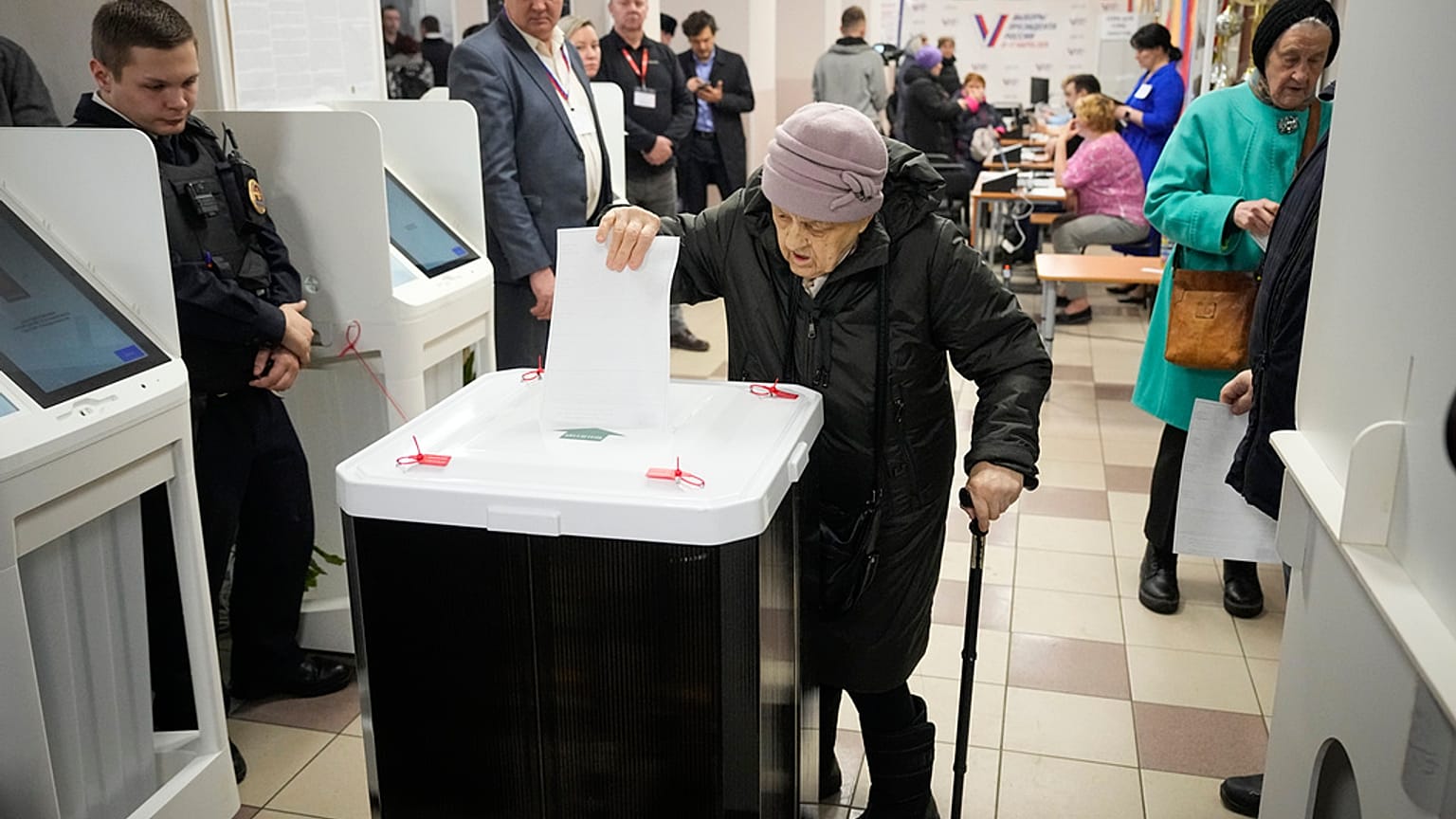 An elderly woman casts a ballot during a presidential election in Moscow, Russia, Saturday, March 16, 2024. 