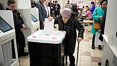 An elderly woman casts a ballot during a presidential election in Moscow, Russia, Saturday, March 16, 2024. 