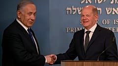 El primer ministro israelí, Benjamin Netanyahu da la mano al canciller alemán, Olaf Scholz