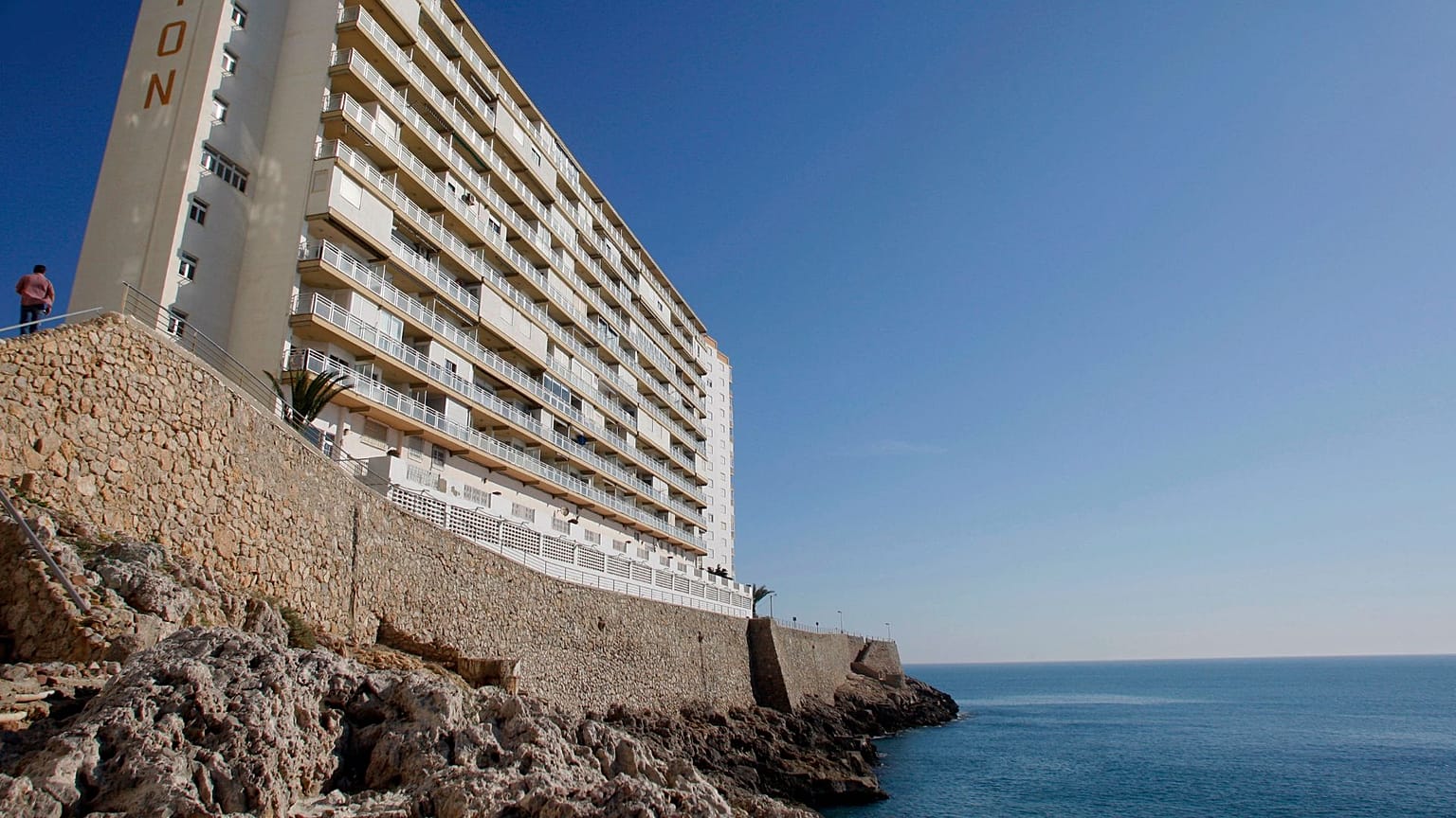 Um homem, à esquerda, caminha em direção a um edifício de apartamentos na aldeia de Cullera, a sul de Valência, Espanha, em abril de 2008. 