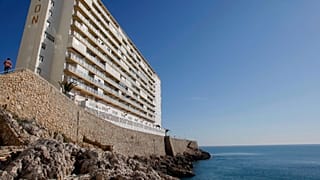 A man, left, walks towards an apartments buillding in Village of Cullera, south of Valencia, Spain, April 2008.
